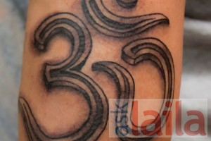 Tiny letter b tattoo handwritten on the inner arm